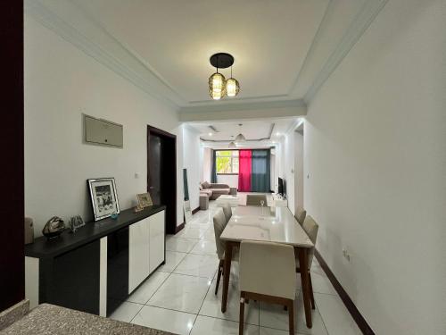 a kitchen and living room with a table and chairs at APARTMENTO LUMINOSO in Malabo