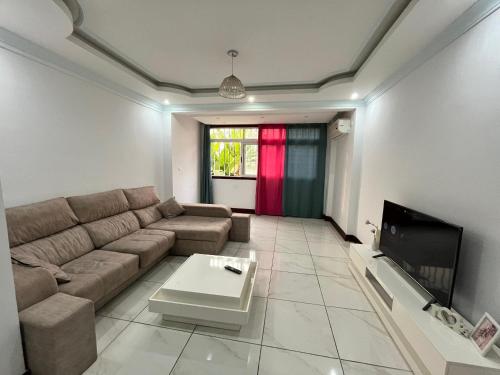 a living room with a couch and a tv at APARTMENTO LUMINOSO in Ciudad de Malabo
