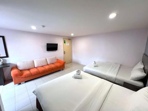 salon z 2 łóżkami i kanapą w obiekcie Your Hotel Klang w mieście Kelang