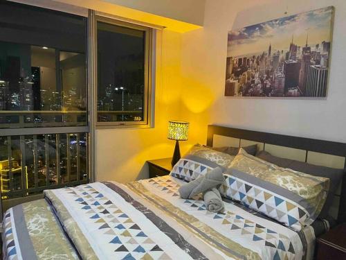 1 dormitorio con 1 cama y vistas a la ciudad en Cool 1BR Acqua Livingstone w/ Netflix, Pool & Gym, en Manila