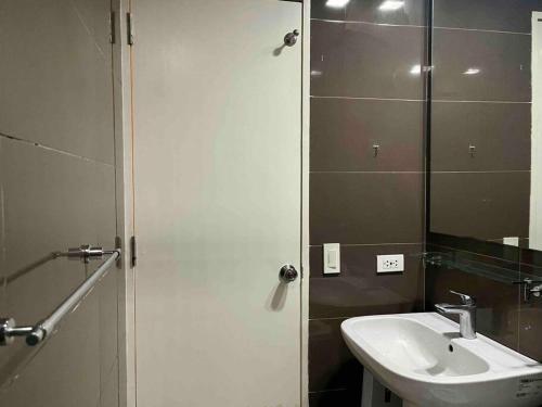 y baño con lavabo y espejo. en Cool 1BR Acqua Livingstone w/ Netflix, Pool & Gym, en Manila