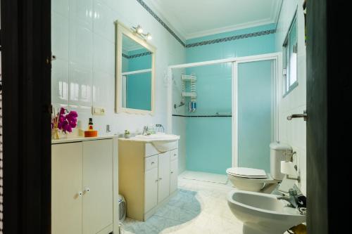 a bathroom with two sinks and a toilet and a shower at Una casa azul in Manzanilla