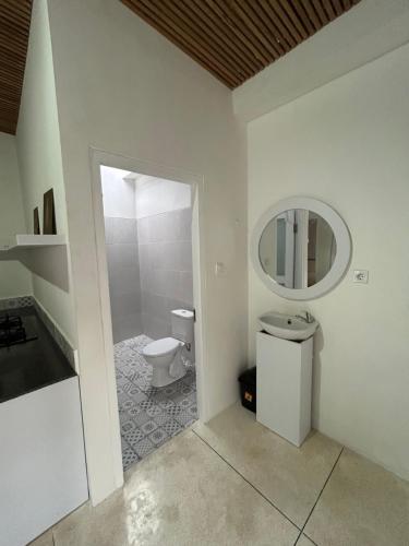 ein Bad mit einem WC und einem Spiegel in der Unterkunft Kusuma Bali House in Ubud