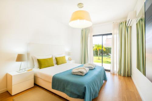アルブフェイラにあるVillas Novochoro - Large Garden- Heatable Poolのベッドルーム1室(ベッド1台、大きな窓付)