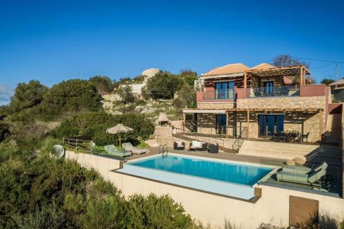 a villa with a swimming pool and a house at Entheos Private Villa Fiskardo Kefalonia Greece in Fiskardho