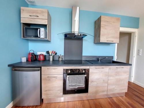 a kitchen with a stove and a sink at LE CARILLOUN in Mirande