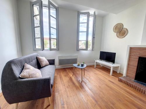 a living room with a couch and a fireplace at LE CARILLOUN in Mirande