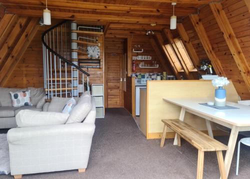 a living room with a white couch and a table at Snowdonia View@puffin Lodges in Chwilog