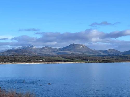 a large body of water with mountains in the background at Snowdonia View@puffin Lodges in Chwilog
