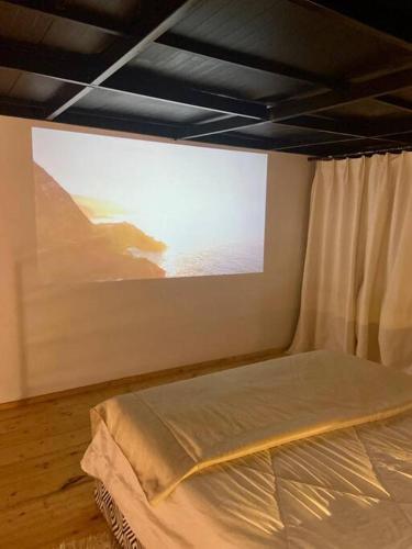a bed in a room with a large screen at Beachside Loft/Cosy house/Design in Tunis