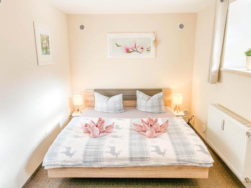 ein Schlafzimmer mit einem Bett mit rosa Blumen drauf in der Unterkunft Alte Försterei in Thale