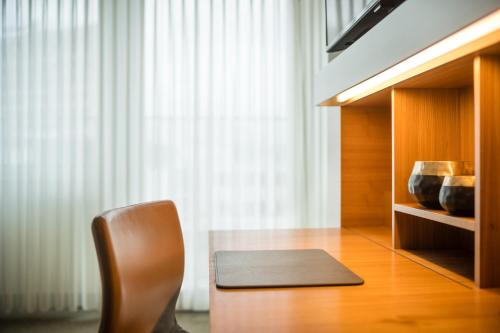 a chair and a table in a room with a window at Lindner Hotel Berlin Ku'damm, part of JdV by Hyatt in Berlin