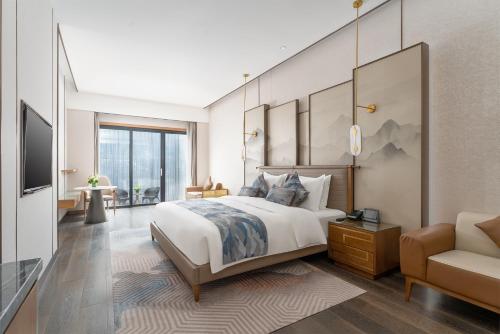 Schlafzimmer mit einem Kingsize-Bett und einem Stuhl in der Unterkunft Holiday Inn Express Pingchang, an IHG Hotel in Bazhong