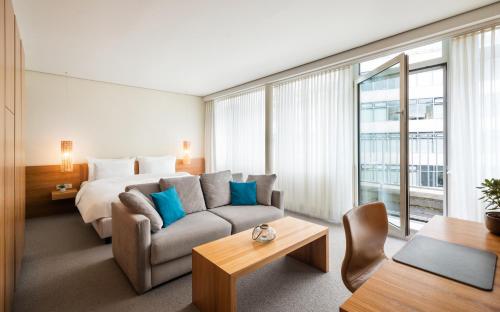 ein Hotelzimmer mit einem Bett und einem Sofa in der Unterkunft Lindner Hotel Berlin Ku'damm, part of JdV by Hyatt in Berlin