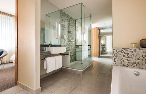 a bathroom with a glass shower and a sink at Lindner Hotel Berlin Ku'damm, part of JdV by Hyatt in Berlin