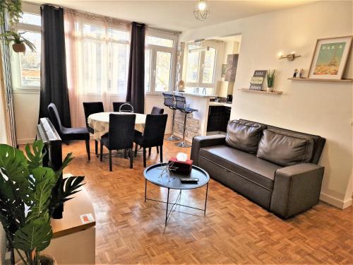 una sala de estar con un sofá y una mesa en Appart' convivial 3 Ch 73m² à proximité de Paris, en Châtillon