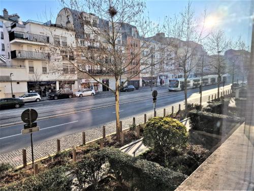 Una vista de una calle de la ciudad con coches en la carretera. en Appart' convivial 3 Ch 73m² à proximité de Paris, en Châtillon