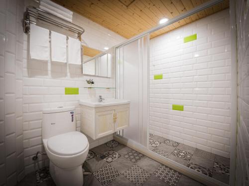 a white bathroom with a toilet and a shower at Good Time Boutique Hotel in Kaohsiung