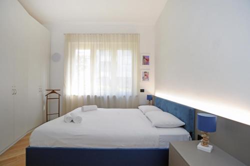 two beds in a small room with a window at Art Lover Apartment in Milan