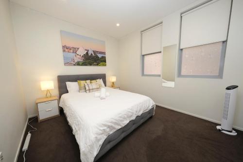 a bedroom with a large bed and two windows at Alora Apartment in Sydney CBD - Darling Harbour in Sydney