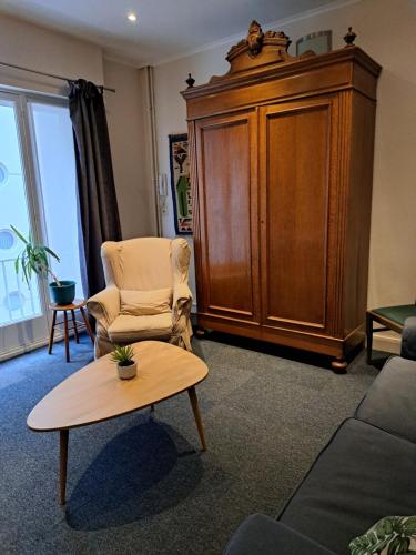 ein Wohnzimmer mit einem Stuhl und einem Couchtisch in der Unterkunft Apartment Van Hecke in Blankenberge