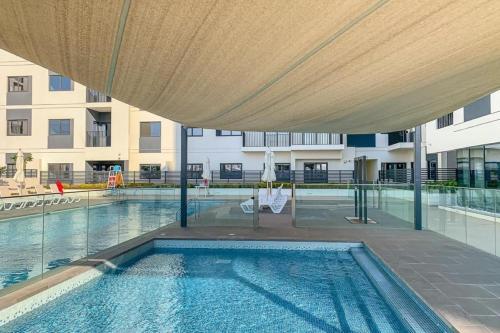 a swimming pool in a building with a large umbrella at Silk Valley - Furnished 2bhk Close To Metro in Dubai Marina