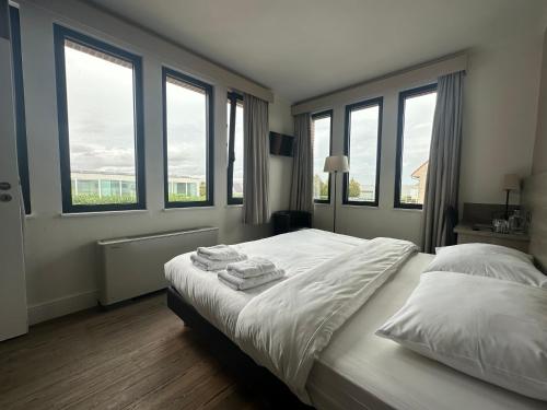Arriate Hotel في لوتشريستي: غرفة نوم عليها سرير بثلاث مناشف
