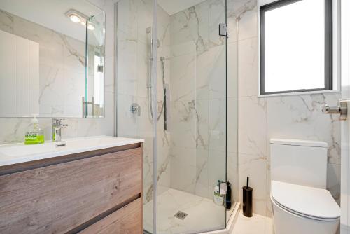 a bathroom with a shower and a toilet and a sink at Te Atatu Cozy Brand New House 4 in Auckland