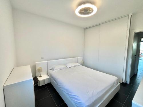 - une chambre blanche avec un lit blanc et une table dans l'établissement Appartement L'Ambiente 2 PORTICCIO, à Porticcio