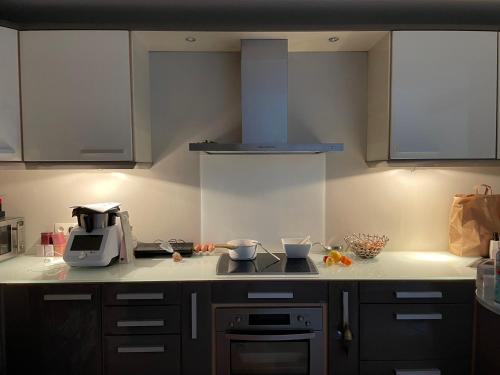 une cuisine avec une cuisinière et un micro-ondes dans l'établissement Maison de ville - versailles château, à Versailles