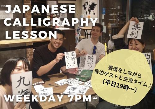 a group of people sitting around a table with signs at Guesthouse Kobe Nadeshikoya in Kobe