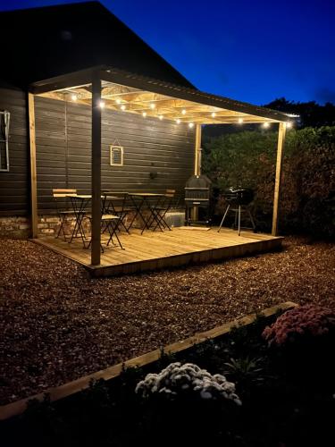 a wooden deck with a grill and lights on it at Belle Vue Farm B&B in Fritham