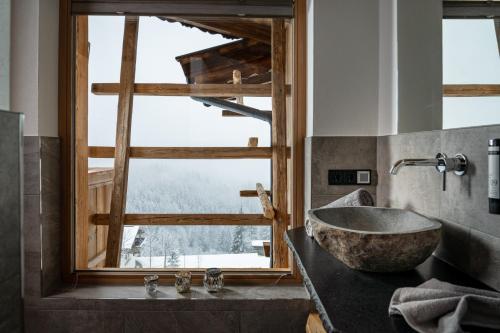 a bathroom with a large stone sink and a window at Wochenbrunner Chalets in Ellmau
