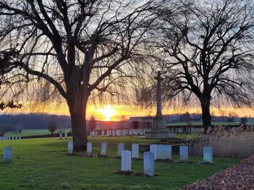 a monument in a cemetery with the sunset in the background at Le Gîte du Mont de la Hutte in Ploegsteert