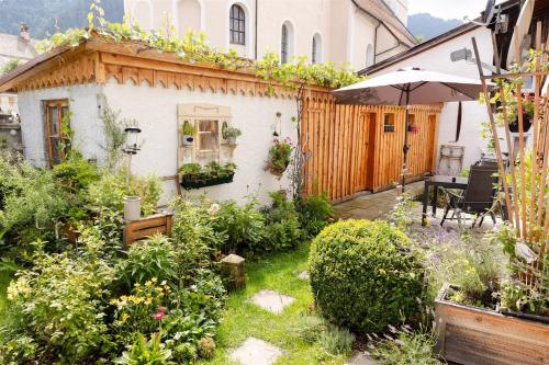 a garden in front of a house with an umbrella at Fewo Schönes Ammertal in Oberammergau