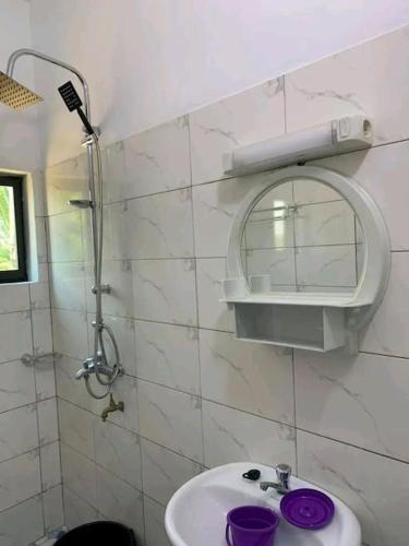 La salle de bains blanche est pourvue d'un lavabo et d'un miroir. dans l'établissement Belle villa neuve meublée à Baguida, à Baguida