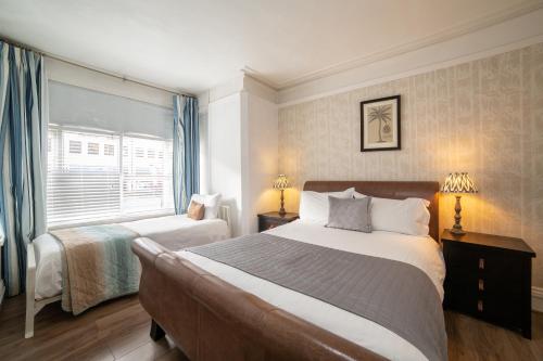 a bedroom with two beds and a window at OYO Lonsdale Guest House in Oxford