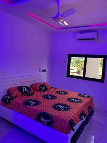 Un dormitorio con una habitación púrpura con una cama en Belle villa neuve meublée à Baguida en Baguida