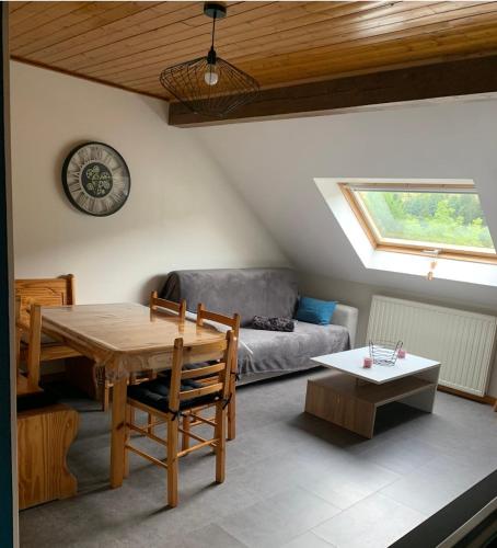 un salon avec une table et un canapé dans l'établissement Appartement 6/8 pers Le Petit Bertin, à La Bresse