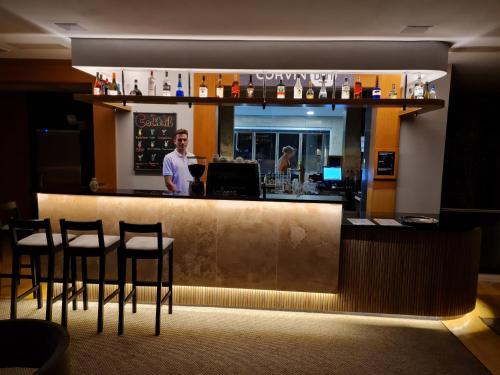 a man standing at a bar in a restaurant at Hotel Visegrád in Visegrád