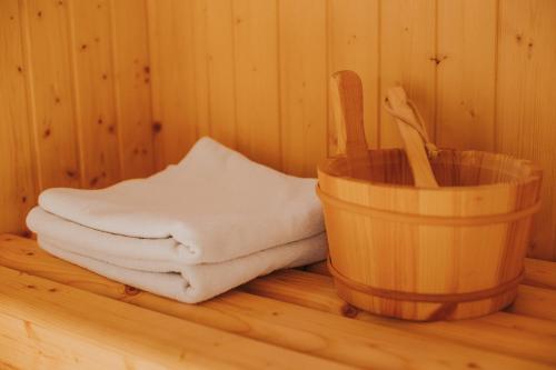 a stack of towels in a sauna with a bucket at Complex turistic Han Pescaresc in Nyàradremete