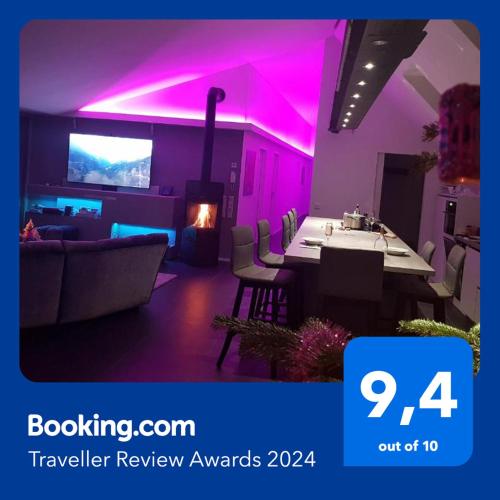 a living room with a table and a room with purple lights at Dachgeschoss Designer-Loft Arlberg - Montafon in Bludenz