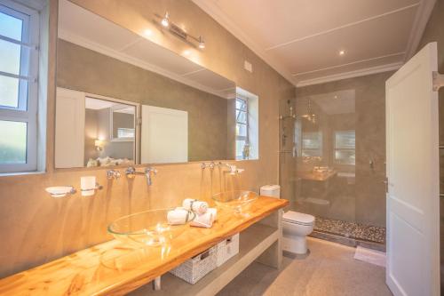 a bathroom with two glass sinks and a shower at A Stone's Throw Accommodation in Grahamstown