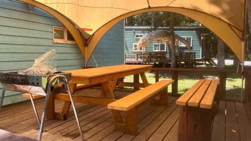 - une table de pique-nique et des bancs sur une terrasse avec une tente dans l'établissement Work Shop Camp Resort Forest and Lake Paradise - Vacation STAY 85272v, à Fujikawaguchiko