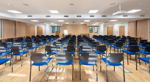 an empty room with blue chairs and desks at Hotel Visegrád in Visegrád