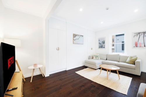un soggiorno con divano e TV di 2 bedroom apartment in trendy Potts Point a Sydney