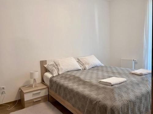 een slaapkamer met een bed met twee handdoeken erop bij Comfortable place on the Marina port in Boedapest