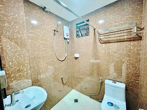 uma casa de banho com um chuveiro, um WC e um lavatório. em OYO 1045 Rayjan Apartelle em Manila