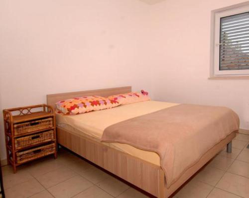 een bed met 2 kussens en een nachtkastje in een slaapkamer bij Matea in Novalja