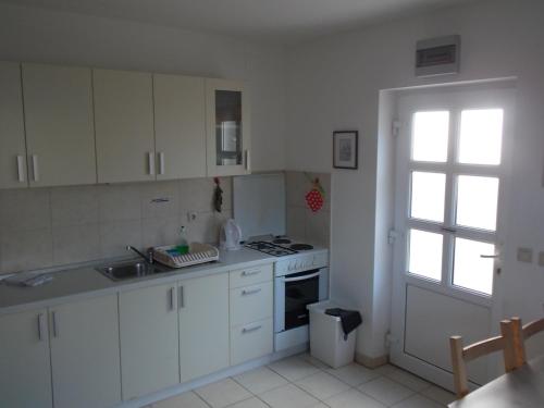 een keuken met witte kasten, een gootsteen en een raam bij Matea in Novalja